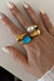 Pearl of the West Stone Crossed Ring in White — Worn view, stacked with Brown and Blue