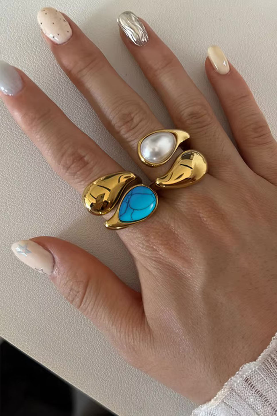 Pearl of the West Stone Crossed Ring in White — Worn view, stacked with Brown and Blue