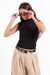 Sage the Label Coralie Mock Neck Top in Black — Front view, adjusting sunglasses